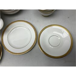 Royal Doulton Royal Gold pattern tea and dinner service for eight, comprising dinner plates, side plates, tea plates, soup bowls, sauce boat and saucer, dessert bowls, coffee cans and saucers, teacups and saucers and two lidded tureens