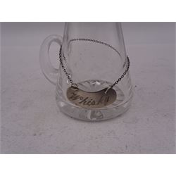 Modern Scottish silver mounted glass whisky tot, with silver whisky label, the glass body with C handle and star cut base, the silver collar and cover with thumbpiece, tot and label hallmarked Edinburgh1996, maker's mark K.M.S, tot including thumbpiece H10.5cm