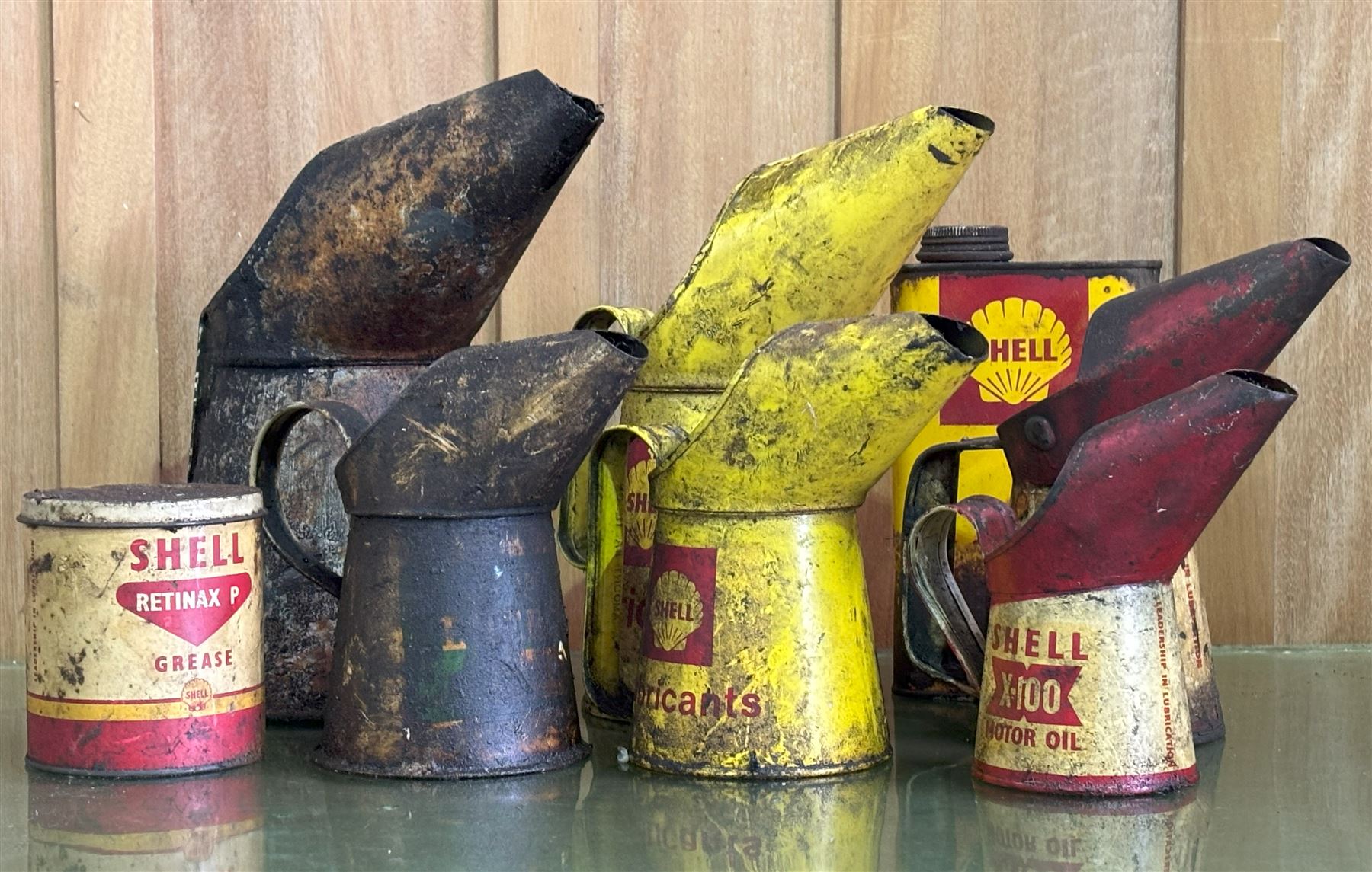 Graduated pair of Shell lubricants oil pourers, together with a graduated pair of Shell X-100 oil pourers, a Shell grease tin, a Shell motor oil tin, a BP Lubricants oil pourer, and another (8) - COLLECTION BY APPOINTMENT FROM: The White House, Thirsk Road, Easingwold, York, YO61 3NF - CALL 01723 507111 TO ARRANGE