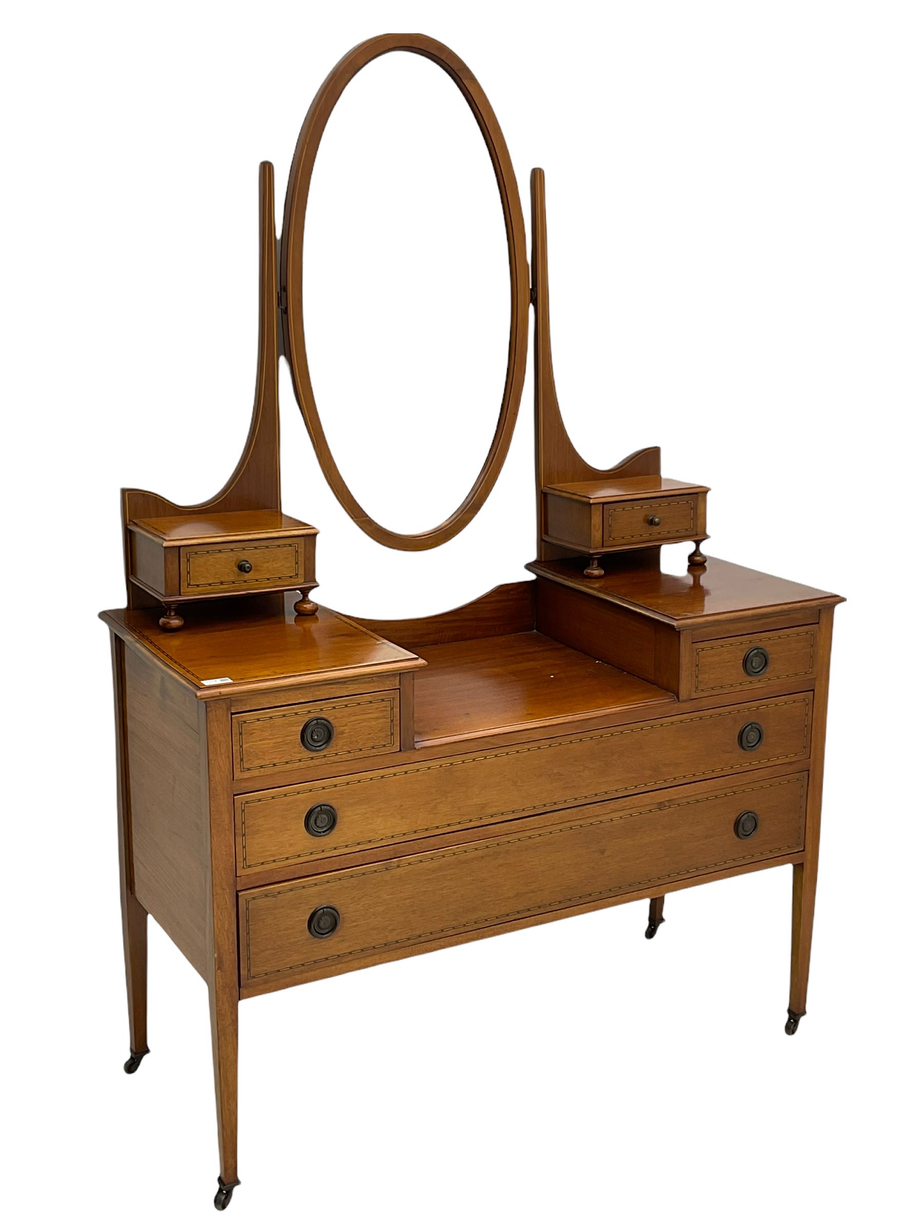 Edwardian inlaid mahogany dressing table, oval swing mirror, trinket drawers, above two small and two long drawers