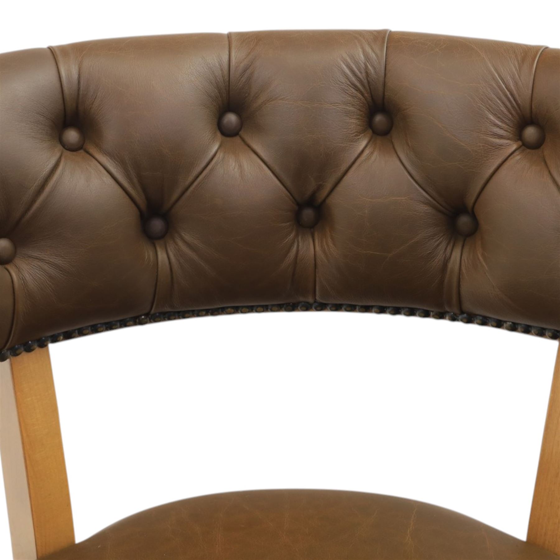 Captain's swivel desk chair upholstered in buttoned tan leather, button backed chair rail, padded and downswept arms, raised on a six point base with castors