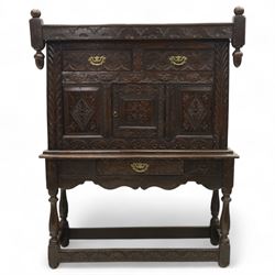 19th century and later carved oak court cupboard, the upper section with two drawers above a central cupboard door flanked by panels, lower section with single long drawer, on turned supports united by carved stretchers