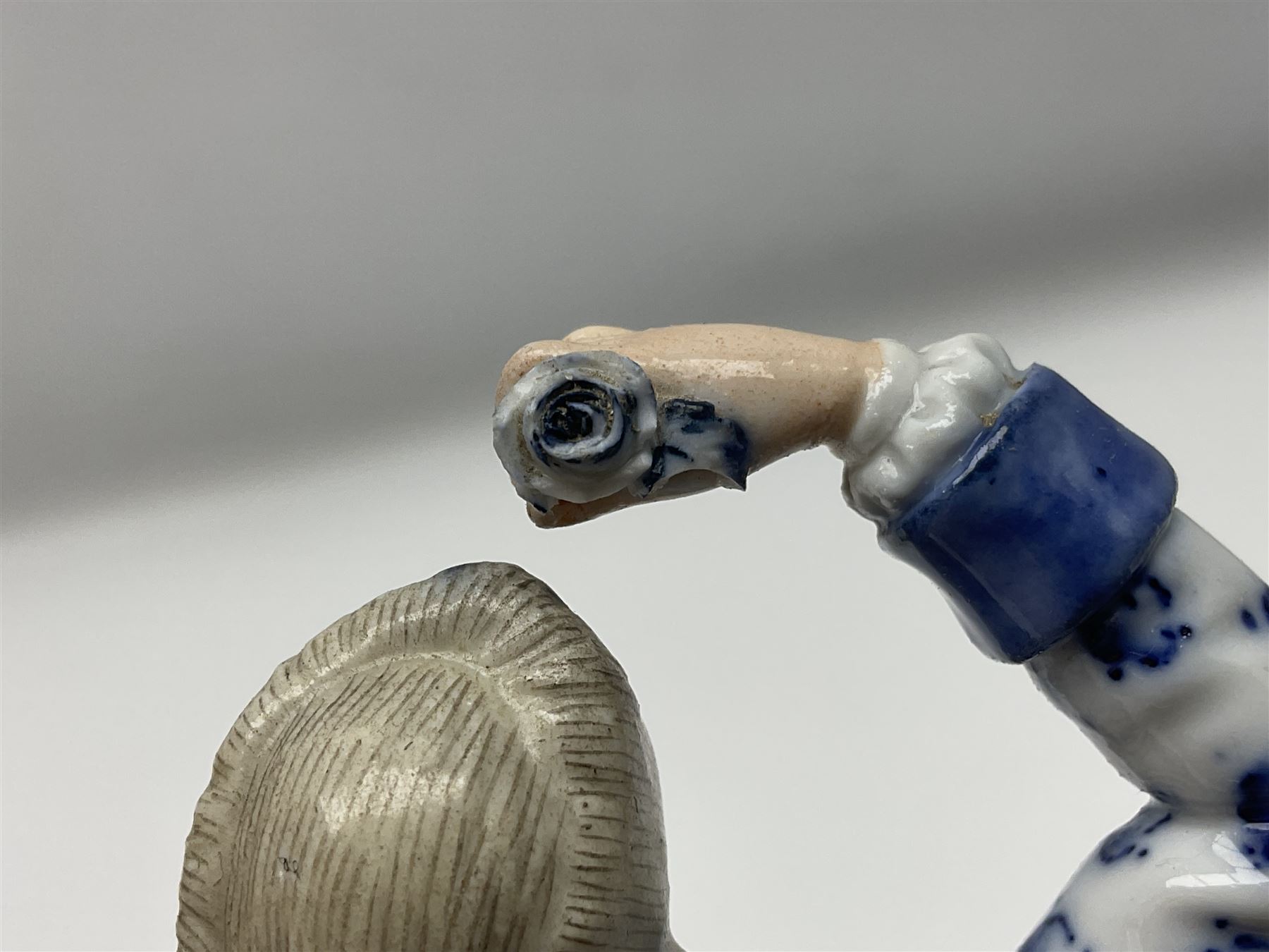 Meissen blue and white figure, modelled as a gentleman holding a hat of flowers, raised upon Greek key design base, with blue crossed swords and impressed C 73 and 149 marks beneath, H18cm