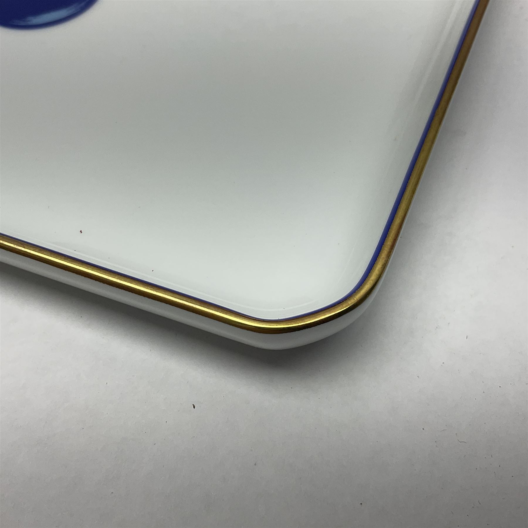 Limoges for Cartier, ceramic trinket dish, of rectangular form with rounded corners, decorated to centre with leopard upon a blue ball, with blue and gilt rim, with printed mark beneath, in original box, H15.5cm, W21cm