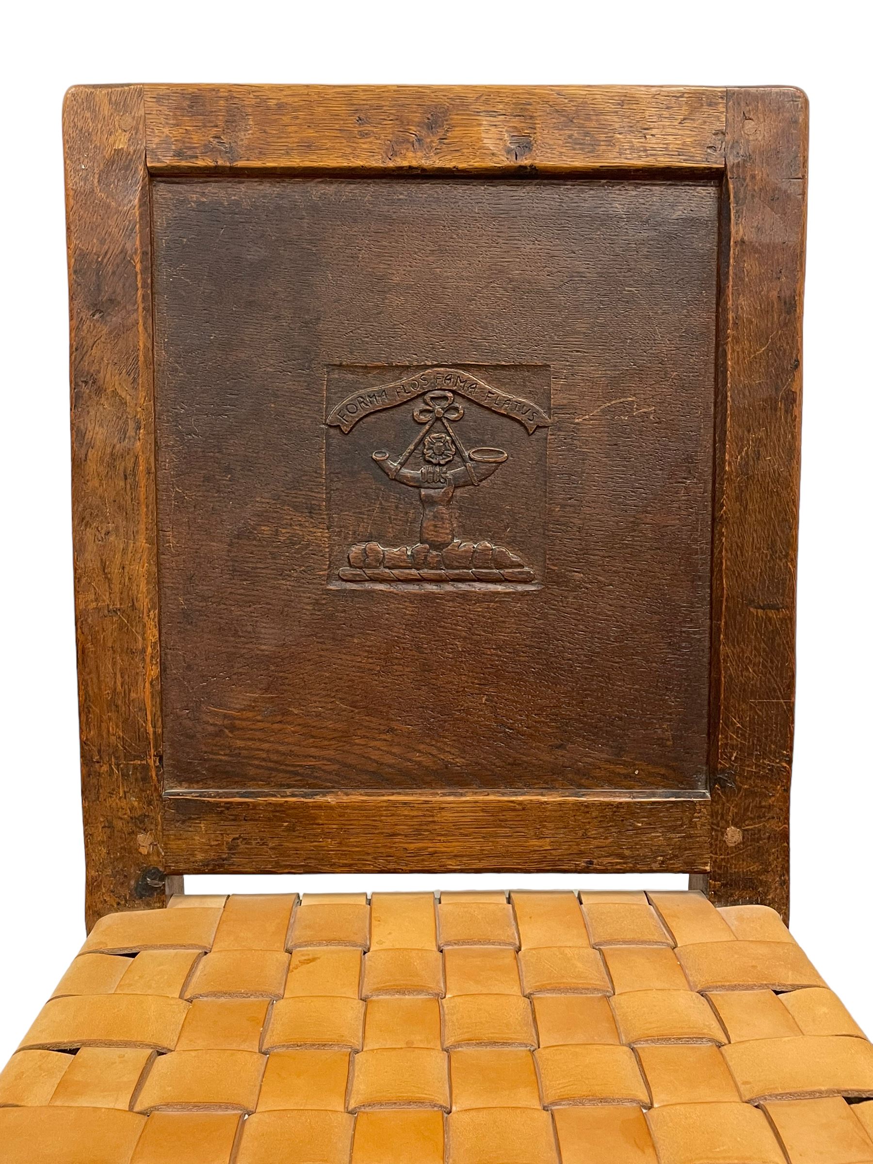 Mouseman - circa. 1930s set of six (4+2) oak dining chairs, panelled back carved with the Bagshawe family crest, the moto 'Forma Flos Fama Flatus' over an arm grasping a bugle-horn with ribbon tie and Yorkshire rose motif, adzed frame, leather lattice strap seat, on octagonal supports united by stretchers, two carvers and four side chairs, each carved with mouse signature, by Robert Thompson of Kilburn 

Provenance: Owned since manufacture by the Bagshawe family, descendants of the Staithes Group Artist Joseph Richard Bagshawe RBA (1870-1909).