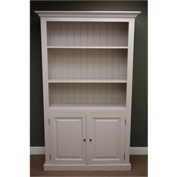  Painted pine bookcase, projecting cornice, two shelves above tow cupboard doors, plinth base, W121cm, H200cm, D44cm  