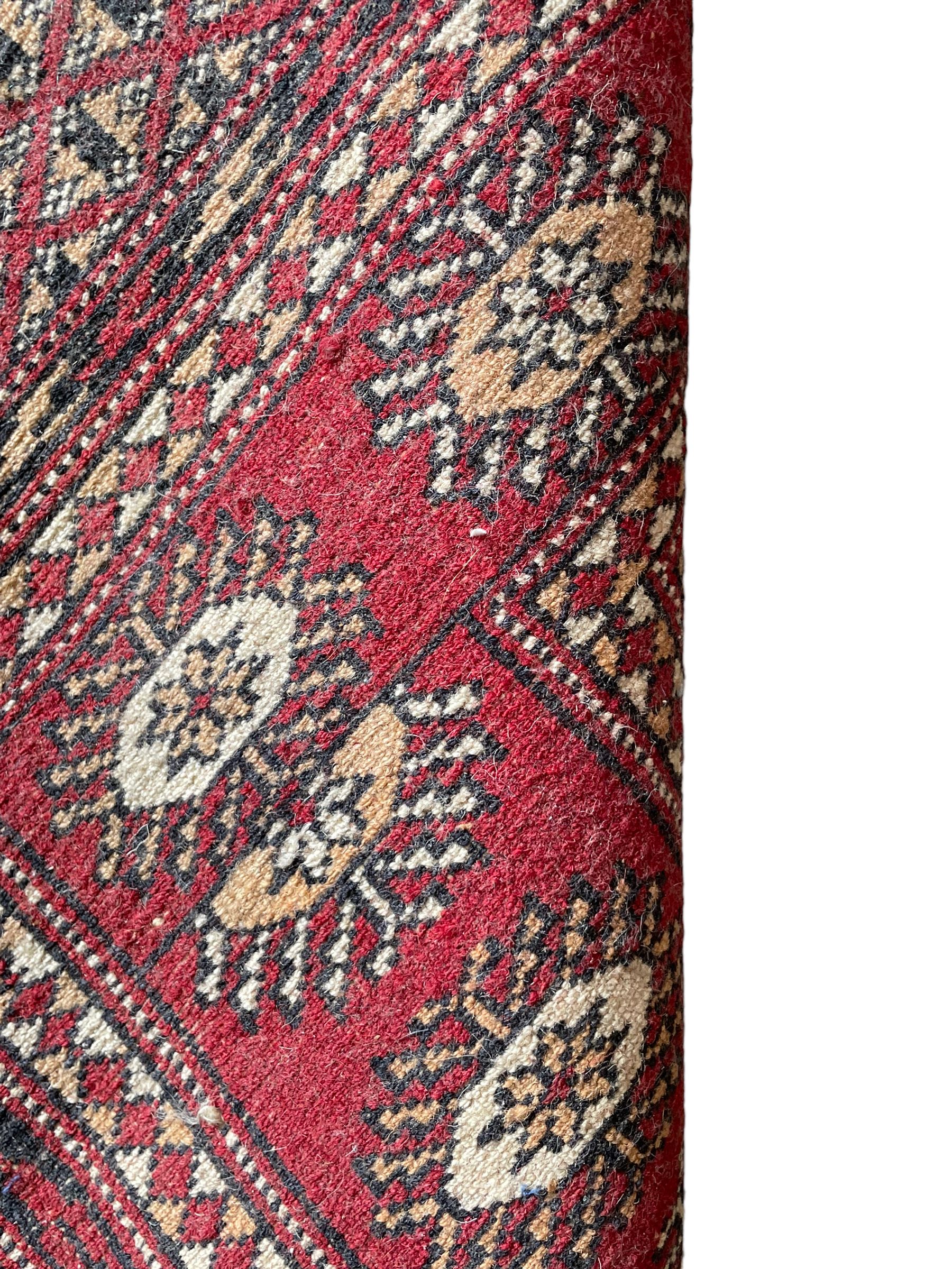 Tekke Bokhara red ground rug, decorated with two rows on Gul motifs, geometric design borders decorated with stylised floral motifs 