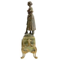 French-Edwardian green onyx clock garniture with a shaped case surmounted by a cast patinated figure of  a maiden in 18th century dress, with gilded scroll feet and conforming mounts, porcelain dial with Arabic numerals and floral decoration, twin train rack striking movement sounding the hours and half-hours on a bell, with a matching pair of five light candelabra. With pendulum.    