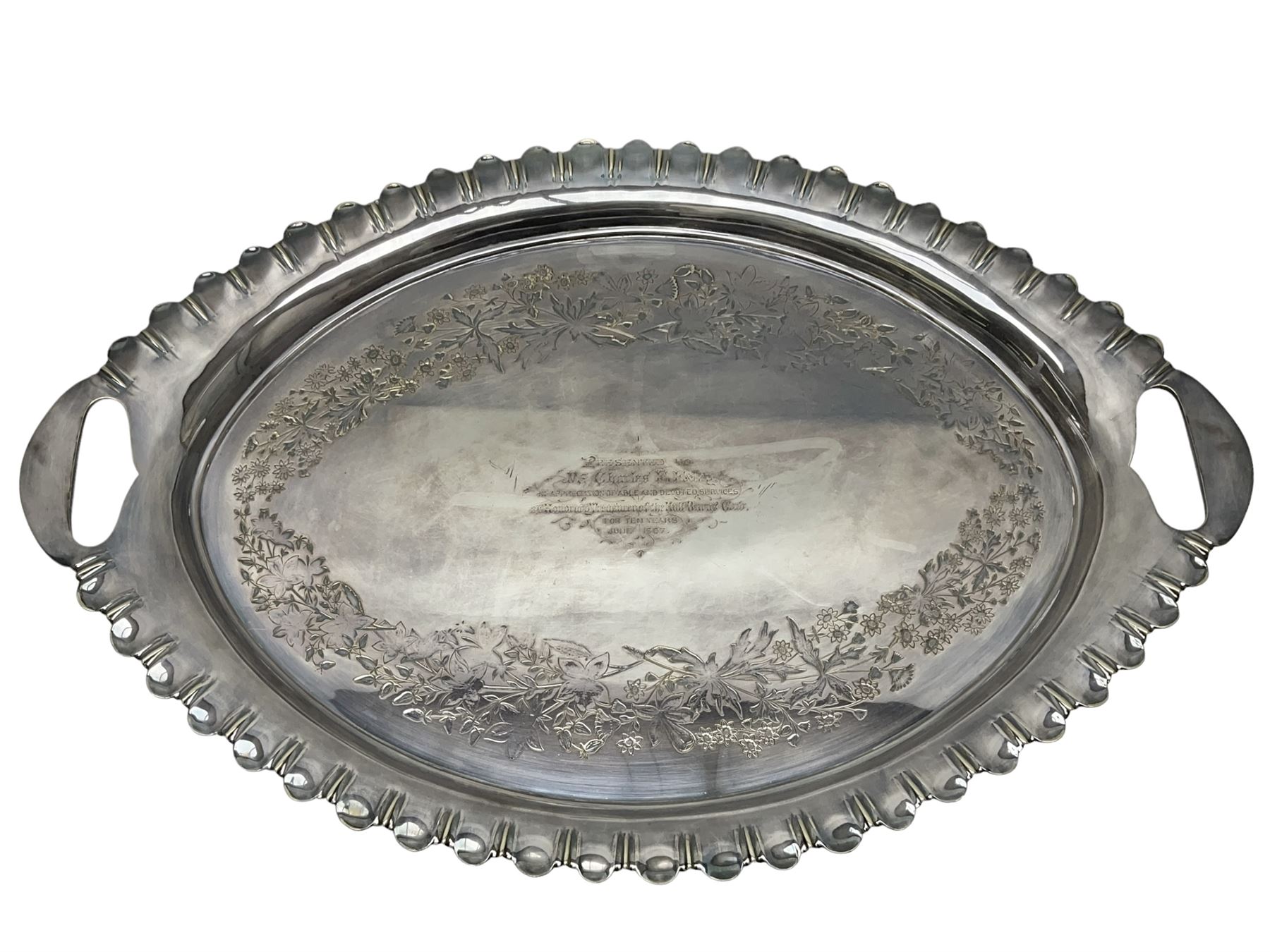 Oval silver plate twin handled tray, egg and dart edge, engraved with floral springs surrounding an central inscription, L65cm