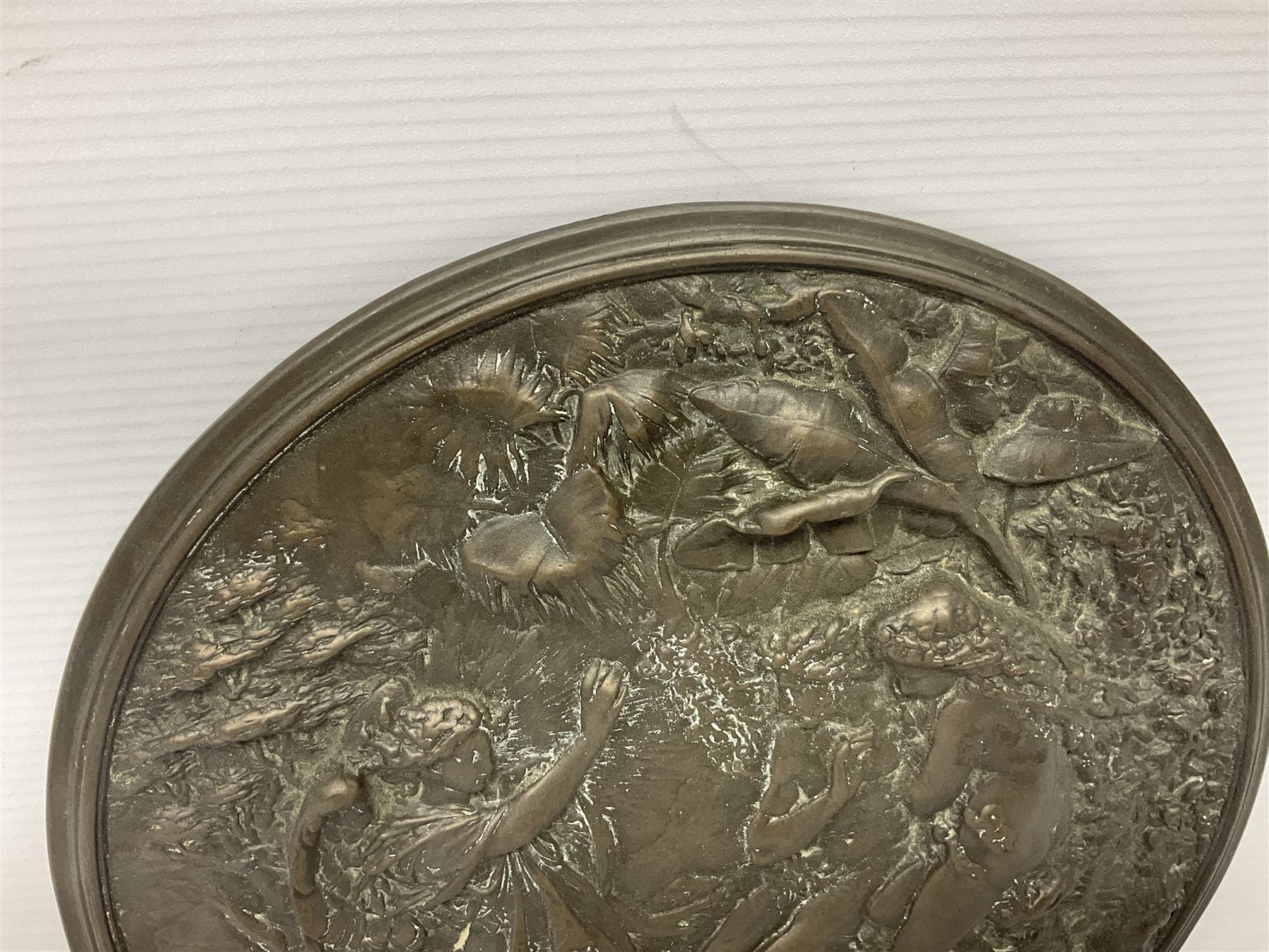 Late 19th century bronze plaque, of circular form, depicting the angel appearing to Adam and Eve in the garden of Eden in high relief, D25.5cm
