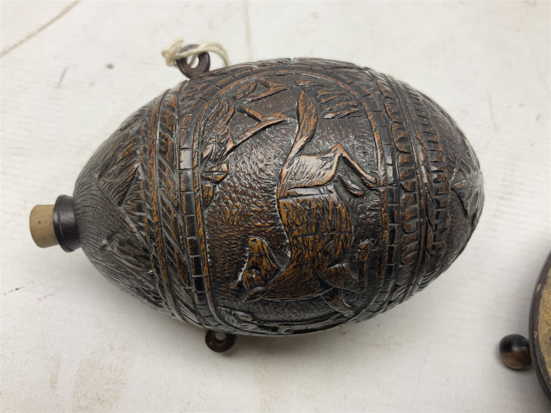 19th century bug bear flask carved with Balkan figures, a wolf and leafage with glass eyes, L14cm on stand 