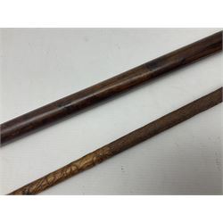 19th century wooden walking stick, the handle carved as a snake within a clenched fist, the cane carved with foliate and cross hatched decoration, with a metal spike to base, together with a turned wooden walking stick, with lacquered rope nautical knot handle, tallest L96.5cm