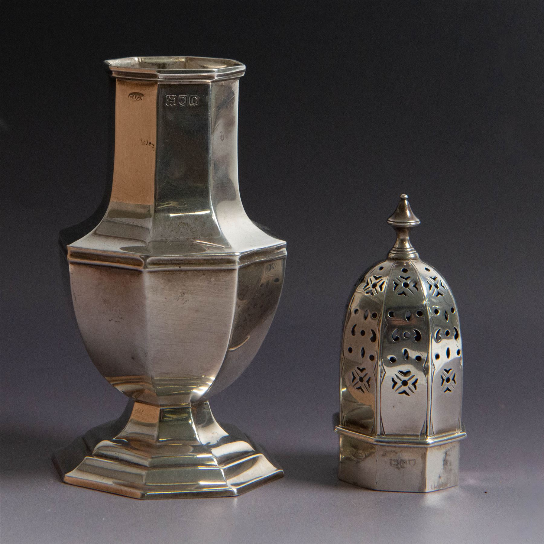 Edwardian silver sugar caster, of octagonal urn form, upon an octagonal foot, the removable pierced cover with urn finial, hallmarked Charles & George Asprey, London 1909, H21cm 