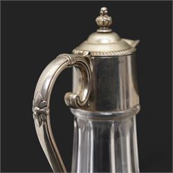 Composite plaque, depicting Sprites in a garden, with inset 'Arts and Commerce Promoted' medallion to reverse, 20cm x 33cm; together with a moulded glass Claret jug with silver plated mount H30cm 