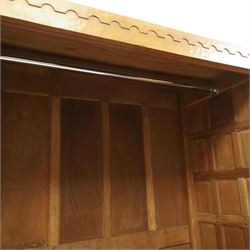 Mouseman - early-to-mid-20th century panelled and adzed double wardrobe, the arcade carved cresting rail over two panelled doors, with wrought metal hinges and latch, deep relief carved mouse signature, the interior fitted with hanging rail, by the workshop of Robert Thompson of Kilburn