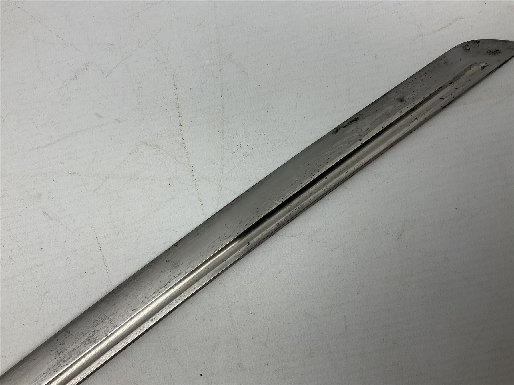 WW2 Japanese Army NCOs sword - katana, the 69.5cm slightly curving fullered blade numbered 14656; arsenal markings stamped near the habaki on the handle; brass tsuba and black painted metal hilt cast to simulate cord bound fish skin; in black painted steel scabbard with single suspension ring L96cm overall