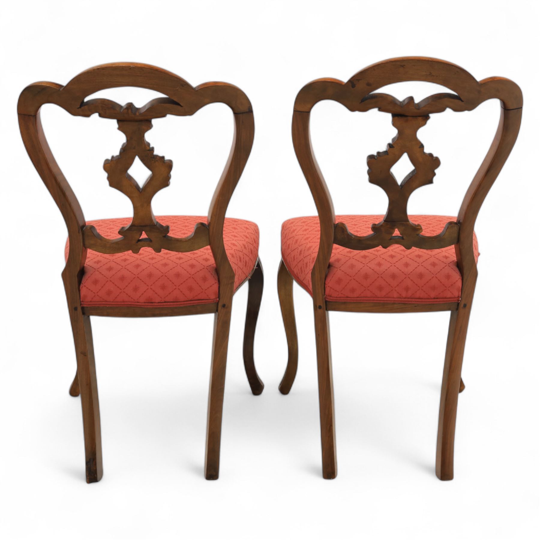 Set of four Victorian walnut balloon back chairs, with a carved and pierced back splat with foliate scrolls, serpentine seat upholstered in a diamond pattern fabric, raised on cabriole legs 