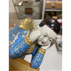 Pair of 20th century Chinese figural bookends, modelled as children in traditional blue dress sat reading and kneeling upon stacks of books, H22cm
