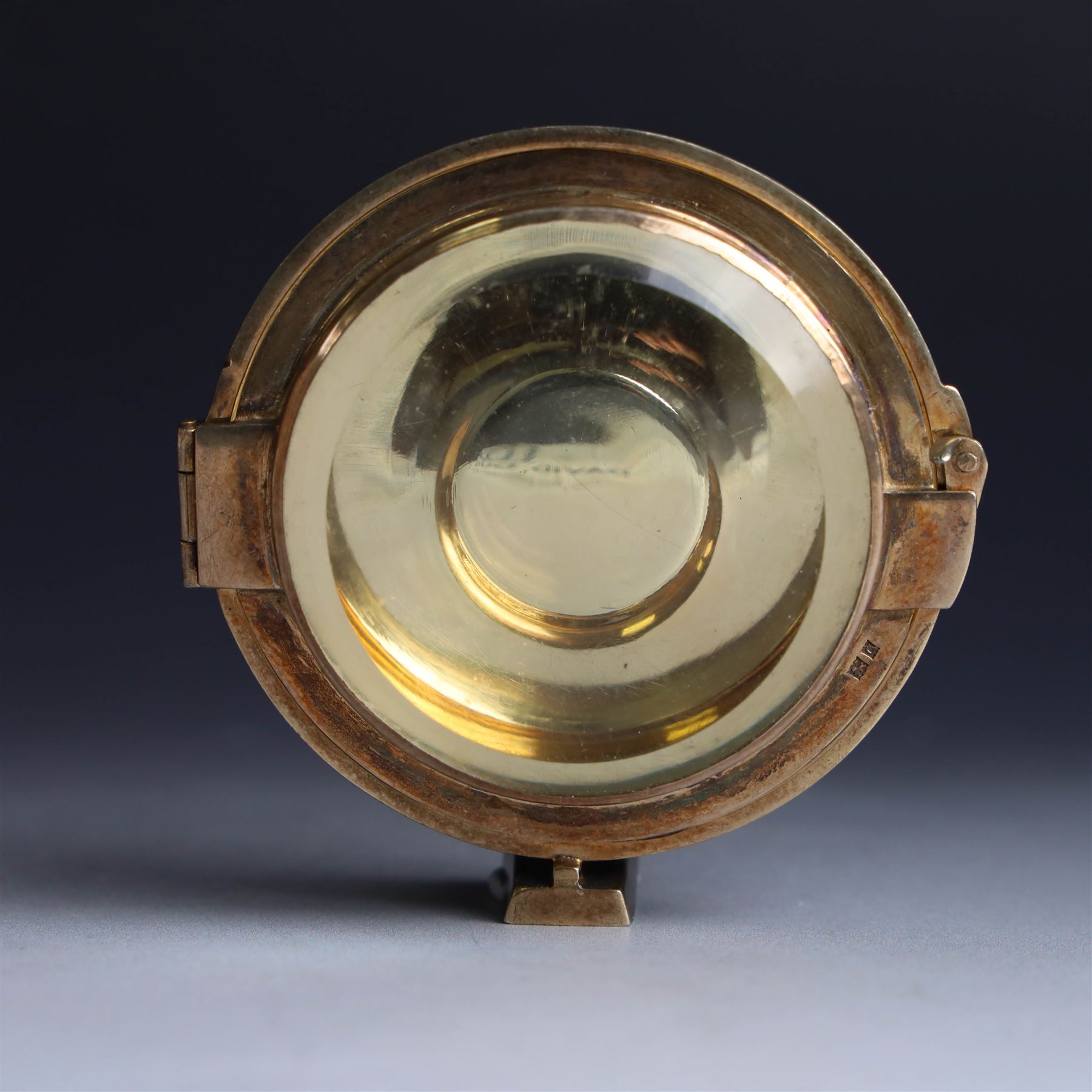 Late 20th century silver-gilt lunette, of circular form with bevelled glass centre, hallmarked Hayes & Finch Ltd, Birmingham 1977, H7.5cm