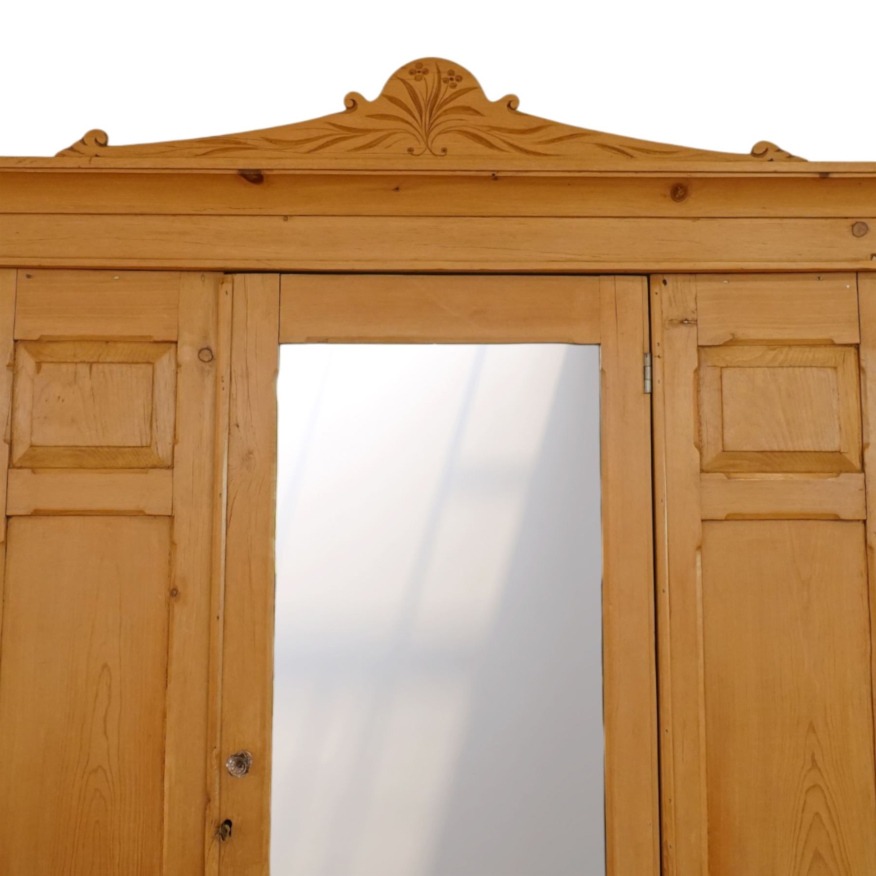 Victorian waxed pine wardrobe, carved projecting cornice with mirrored door, enclosing clothes hooks and rail, above a single drawer with glass knobs