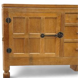 Mouseman - adzed and panelled oak 6' sideboard, fitted with four central drawers and flanking cupboards, enclosed by two panelled doors with wrought metal latches and hinges, on octagonal feet, carved with mouse signature, panelled sides, by the workshop of Robert Thompson, Kilburn 