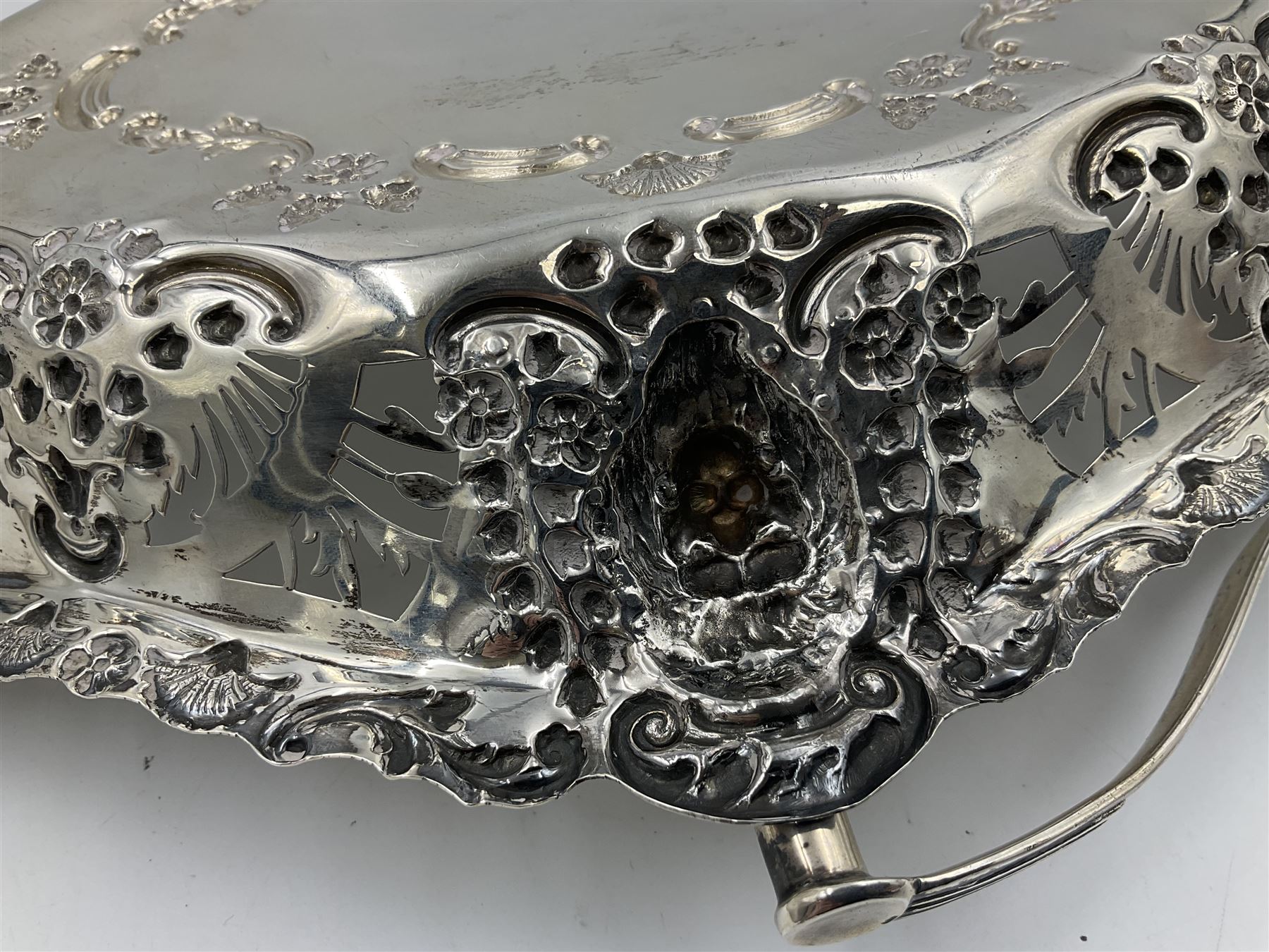 Edwardian silver swing handled basket, of navette form, with four repousse lion masks to each corner and with pierced and embossed floral, scroll and shell decoration to sides, base and handle, hallmarked Charles Horner, Birmingham 1906, height including handle H20cm