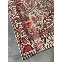 Persian Heriz red and pale ground rug, depicting multiple shaped panels with stylised motifs and designs, geometric patterned border