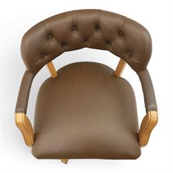 Captain's swivel desk chair upholstered in buttoned tan leather, button backed chair rail, padded and downswept arms, raised on a six point base with castors