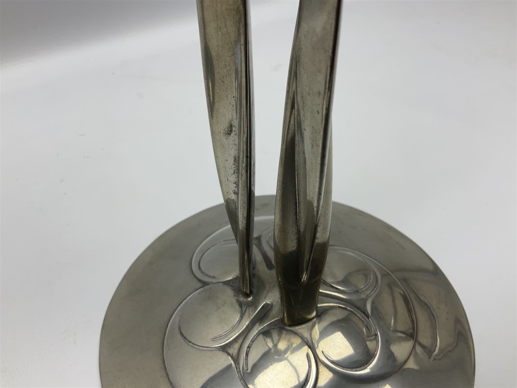 Archibald Knox (1864-1933) for Liberty & Co, pair of Tudric pewter candlesticks, the bud shaped sockets raised upon three angular fin supports and a slightly domed circular base with cast stylised foliate decoration, each stamped beneath Tudric 0223, H30cm