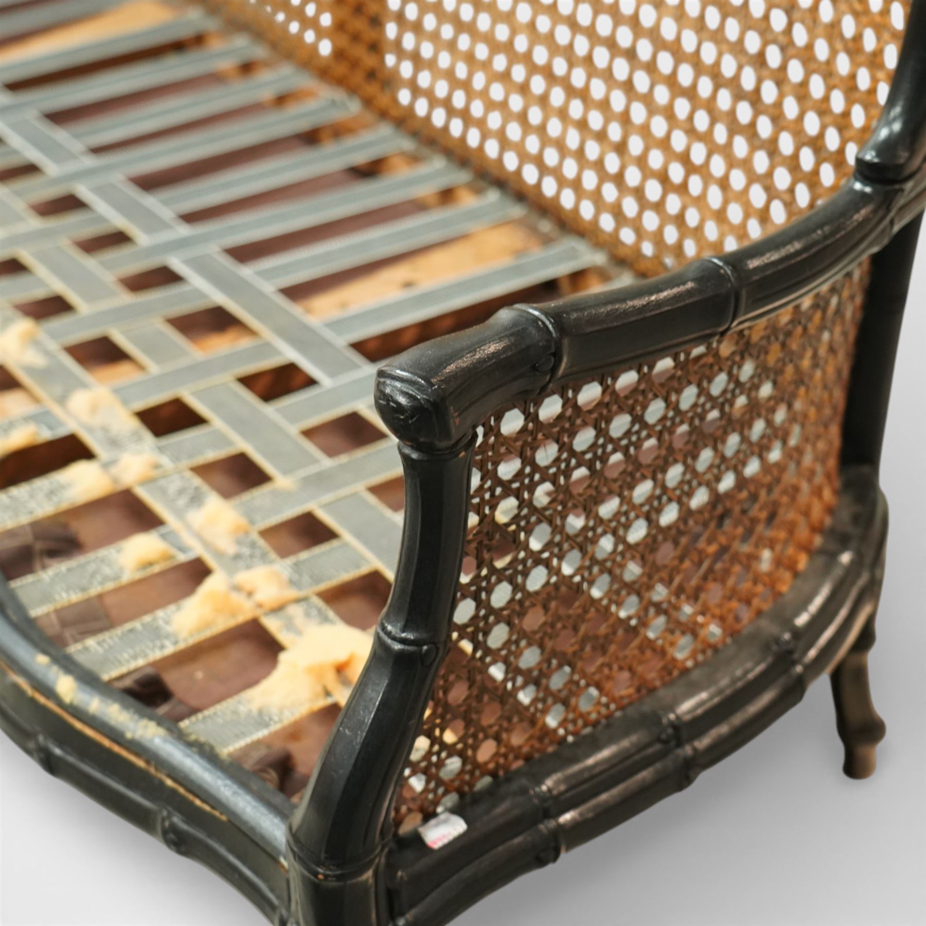 Early 20th century French bergère settee, the shaped caned back flanked by caned sides and scrolling arms, moulded beech frame with dark painted finish, serpentine seat rail with webbing, on cabriole legs with pad feet