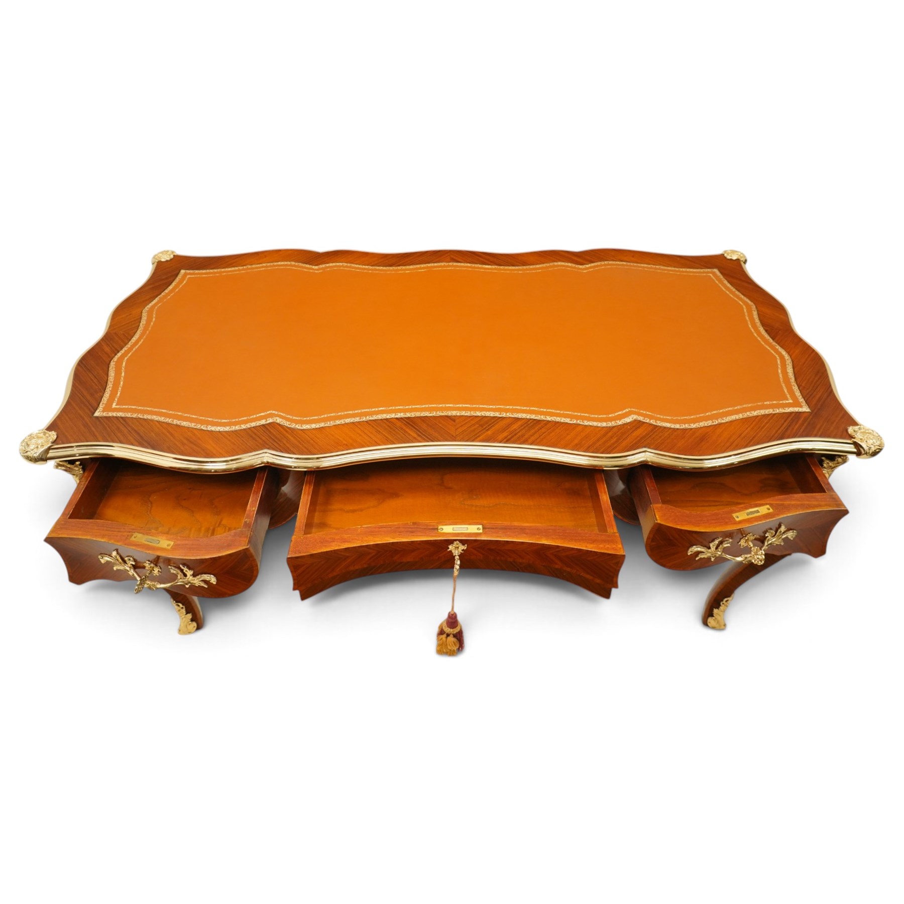 Baggio Anciens Meubles - Italian Louis XV style kingwood and gilt metal mounted bureau plat or writing desk, the shaped rectangular top with inset leather writing surface with gilt metal edge, above three shaped frieze drawers with gilt metal handles, raised on cabriole supports with gilt cartouche mounts to the knees and scroll feet