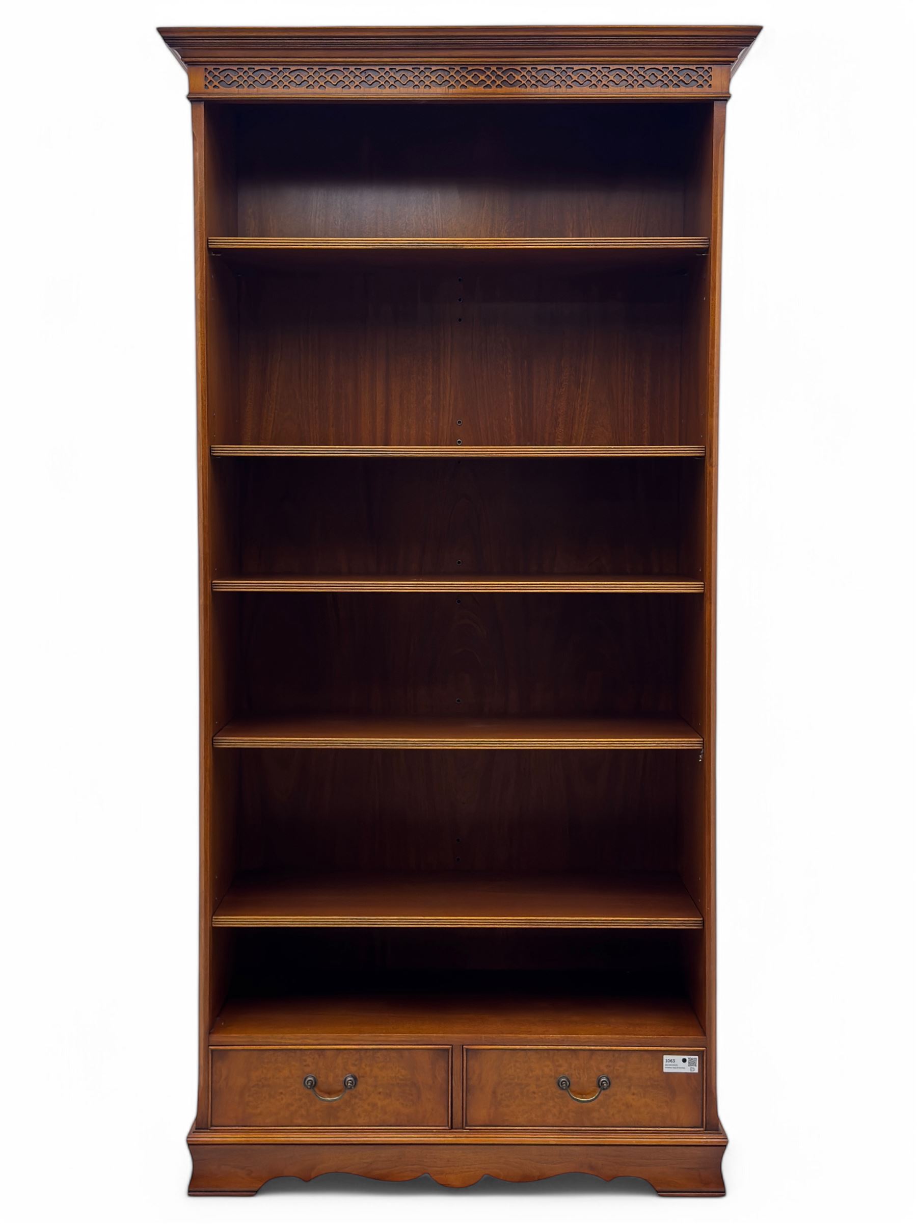 Ian Smith Furniture - Georgian design walnut open bookcase, projecting cornice over pierced geometric frieze, fitted with three adjustable fluted shelves above two drawers, on shaped plinth base 
