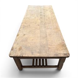 Large early/mid-20th century pine table or work bench, rectangular six plank top on eight tapering supports joined by slatted undertier