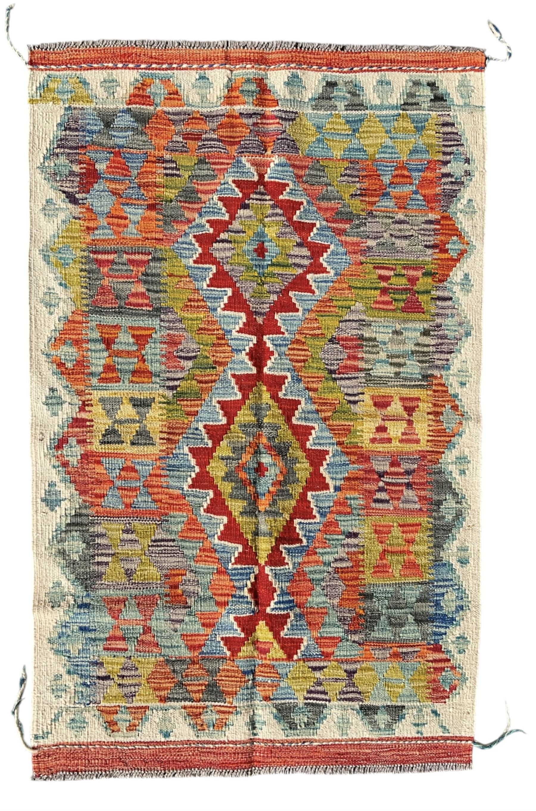 Afghan Chobi Kilim ivory ground rug, central geometric design consisting of stacked lozenge medallions in shades of red, green, and blue, flanked by multicoloured triangular motifs, guarded by zigzag patterns in contrasting tones