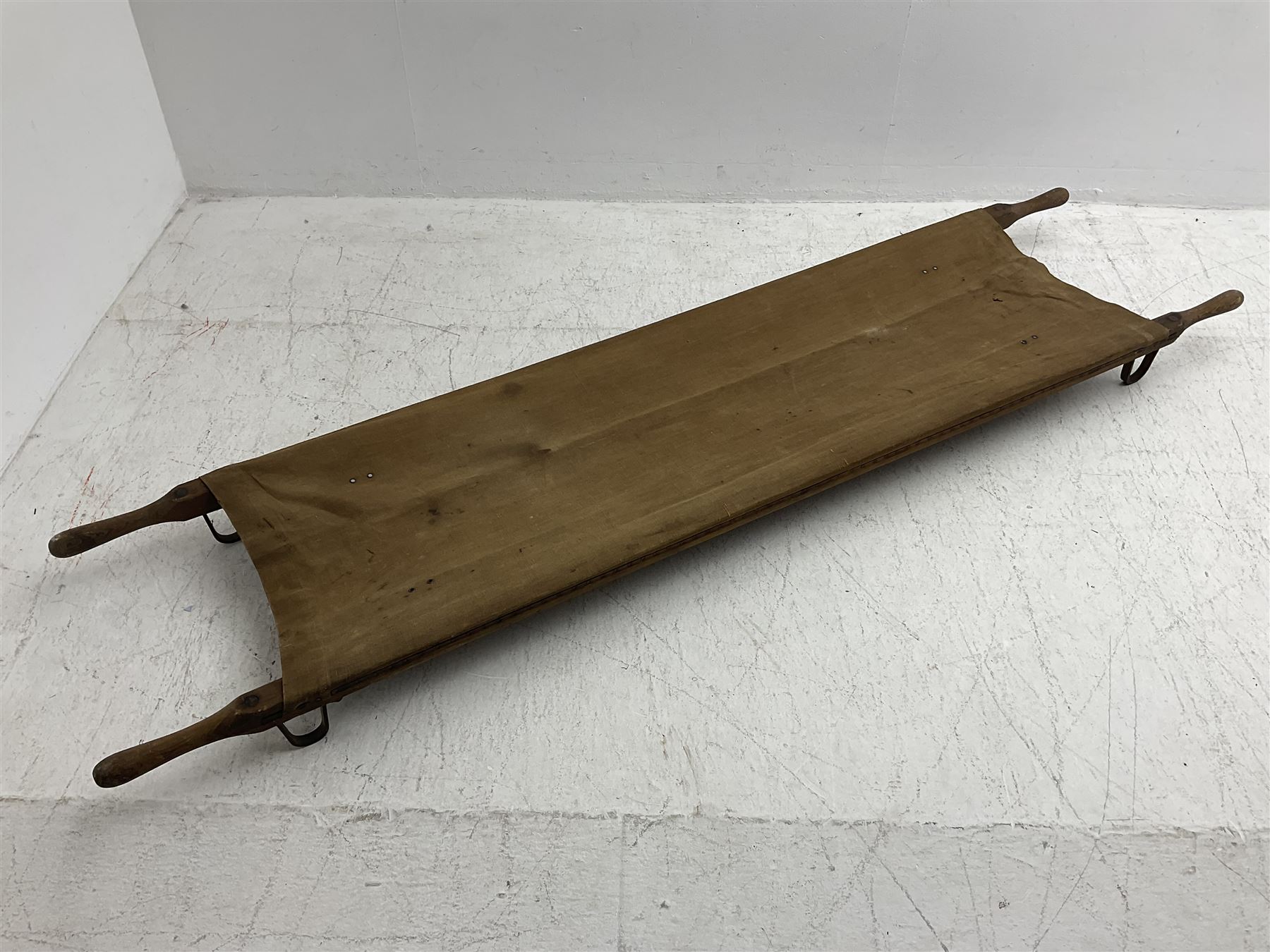 WW1 British casualty stretcher with iron mounted pitch pine sides and canvas base; stamped 'HL1917' and L7 with broad arrow in a triangle L236cm ( reputedly recovered from a barn at Bapaume on The Somme)