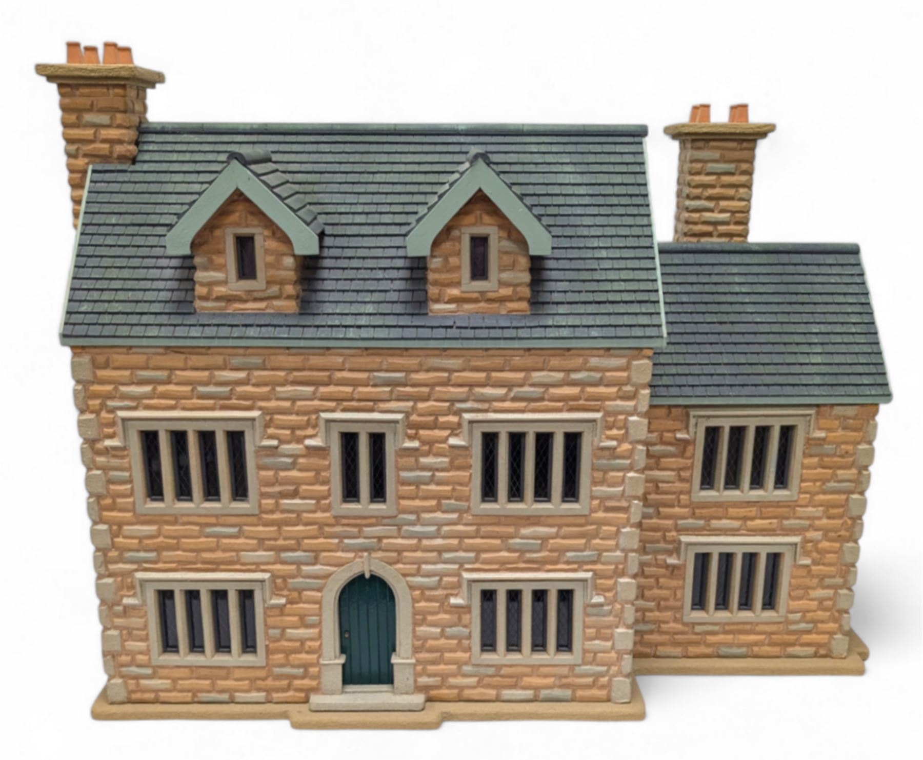 1:24 scale stone effect three-storey cottage dolls house, with green arched door and lattice effect windows, decorated to the interior with wooden floors, wired lighting and fire places, H45cm, W57cm, D26cm