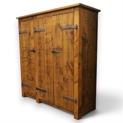 Indigo Furniture - rustic oak triple wardrobe, fitted with three doors with wrought metal fittings and locks, on style supports