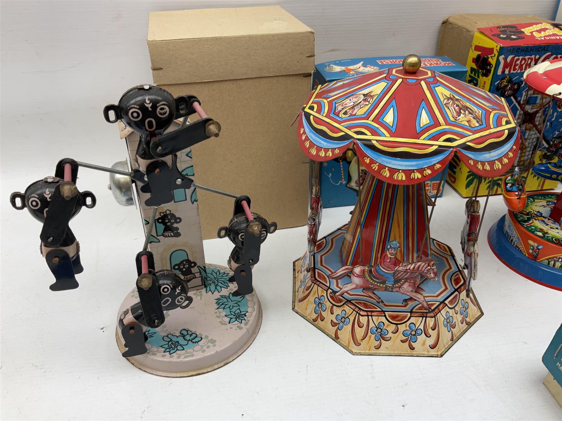 Mid 20th century and later tin plate clockwork toys, to include merry-go-rounds, spaceship carousel, walking robot, Schylling airport control tower, monkey riding horse, astronaut space station etc, including German and Japanese examples, some with boxes (12)