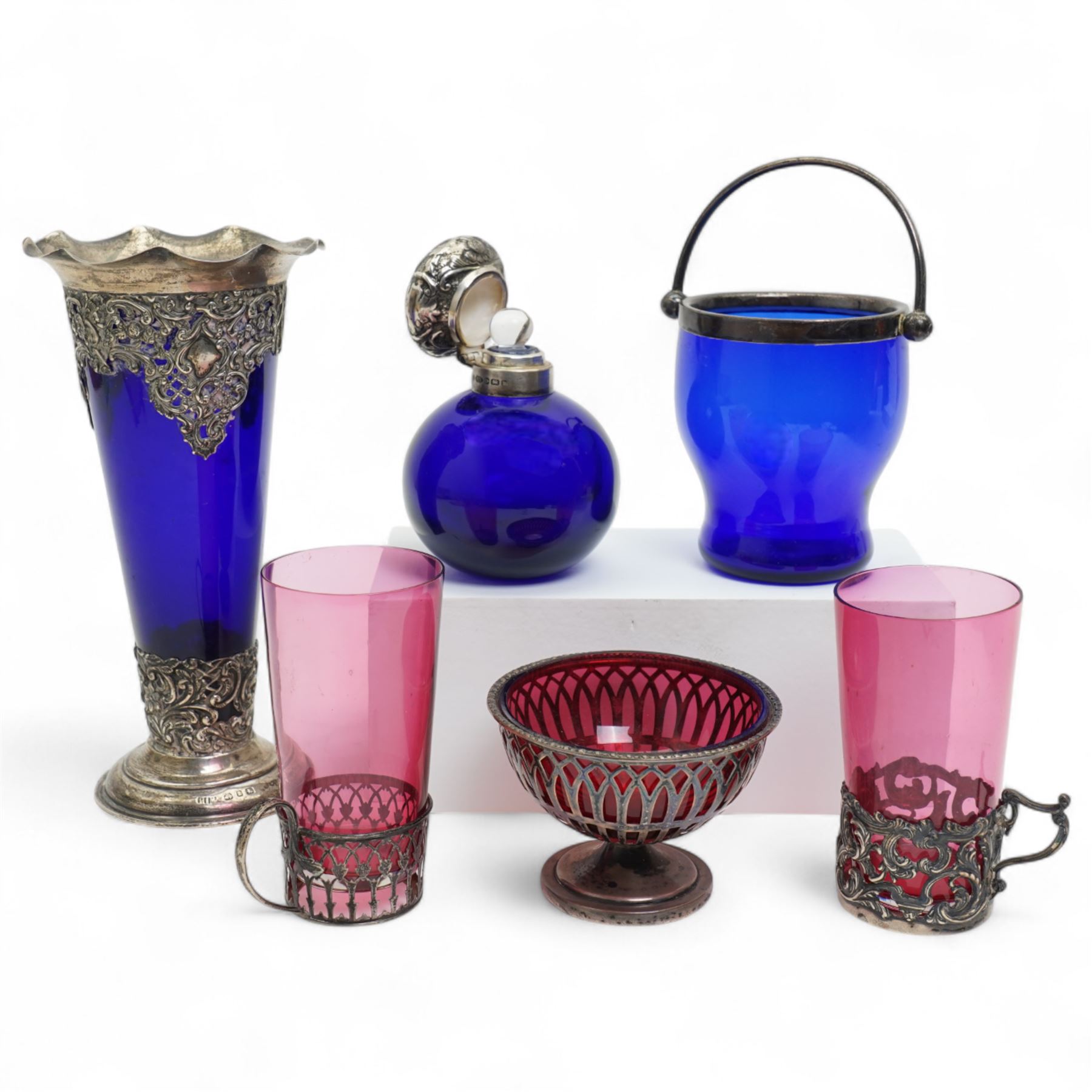 Late Victorian blue glass trumpet shape vase in pierced silver frame H20cm Birmingham 1899, modern blue glass globe scent flask with silver cover, two cranberry glass beakers in silver frames, cranberry sugar bowl in silver frame and blue glass sugar bowl with silver collar 
