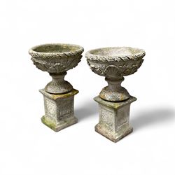 Pair of cast stone ornate garden urns, on plinth bases