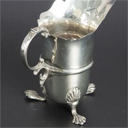 Group of early 20th century silver, comprising sauce boat, with flying scroll handle and upon three pad feet, two small cream jugs and a christening mug, all hallmarked, tallest H10cm