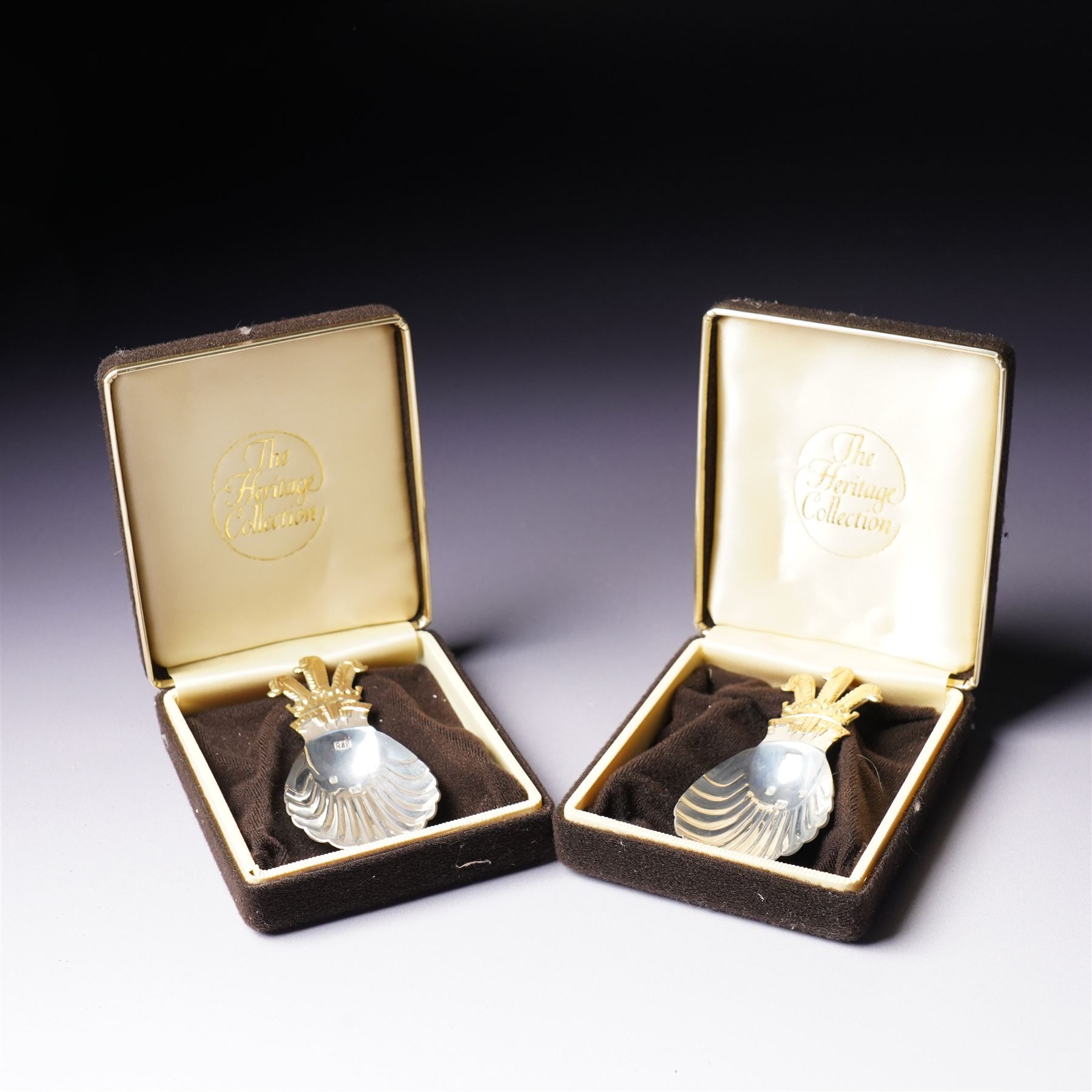 Pair of silver caddy spoons with shell bowls, the handles formed as gilded Prince of Wales feathers in Heritage Collection boxes Sheffield 1981 Maker Roberta & Belk 