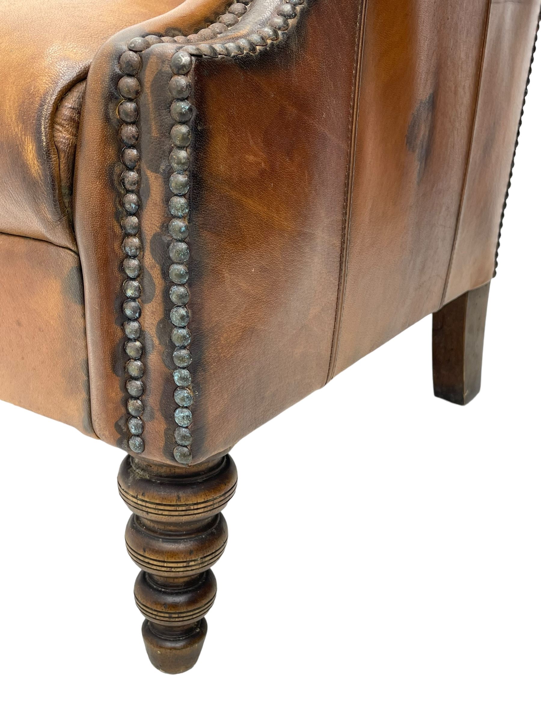 Laura Ashley - hardwood-framed armchair, traditional shape with arched cresting rail over rolled arms, upholstered in buttoned brown leather with studded work, on turned front feet (W76cm, W95cm, D84cm); together with matching rectangular footstool (53cm x 34cm, H29cm)