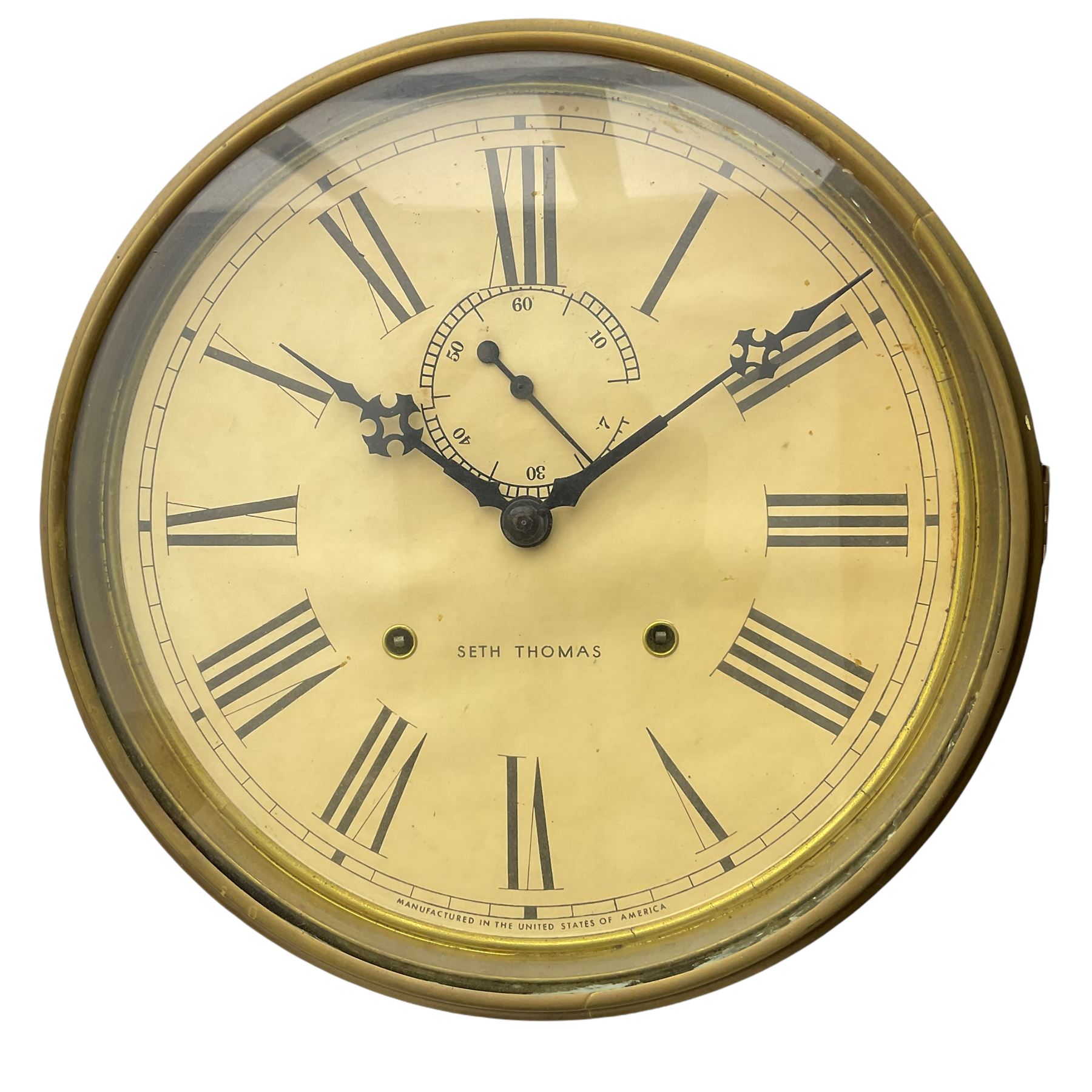 A late 19th century “Seth Thomas” American hexagonal dial wall clock, with a 12” dial within a spun brass bezel and flat glass, with Roman numerals, minute track, subsidiary seconds dial and steel Maltese hands, dial inscribed “Seth Thomas, made in the United States of America”, eight-day spring driven movement striking the hours on a gong, mahogany case with a glazed door and brass slip, visible pendulum and original trade label pasted in the rear of the case.



