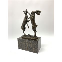 A bronze figure group, modelled as two male hares boxing, upon a naturalistic base signed Nick and with foundry mark, raised upon a rectangular marble base, overall H24cm.