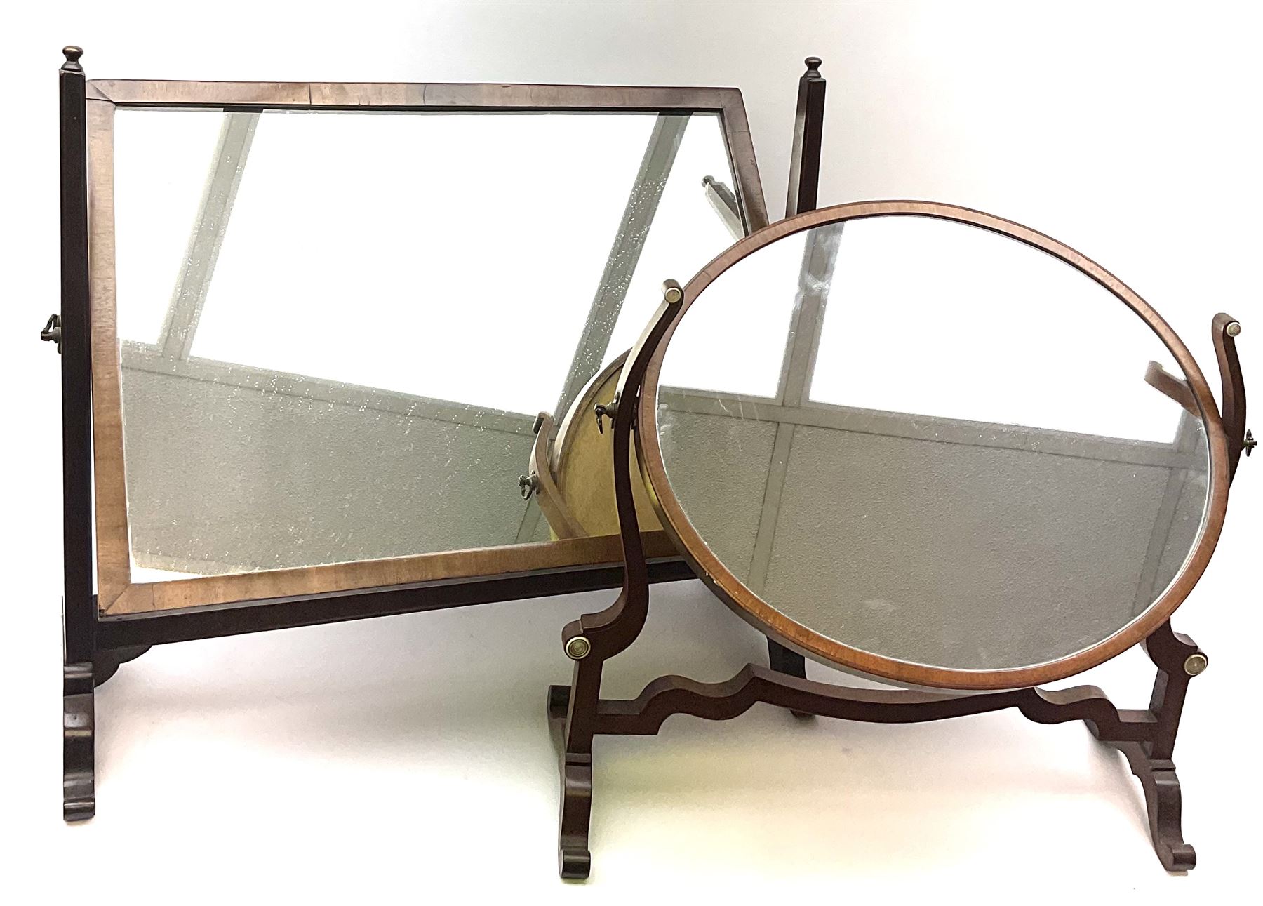 An Edwardian mahogany dressing table mirror, the oval mirror plate in swing frame, upon flared legs linked by stretcher, the frame detailed with turned roundels, H49cm, together with a Victorian mahogany example, H50cm. 