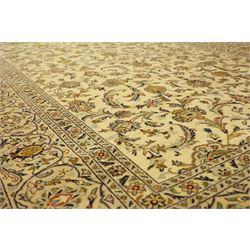 Central Persian Kashan carpet, ivory ground, field with an all-over design of scrolling palmettes and floral sprays in blue and terracotta within a beige ground and pale blue floral border