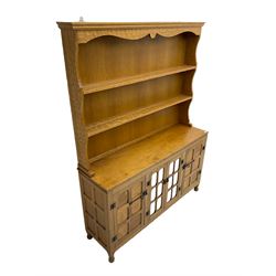 Yorkshire oak - adzed oak dresser, the rack with projecting cornice over shaped frieze and two shelves, the dresser fitted with central glazed double cupboard flanked by two panelled single cupboards, panelled sides