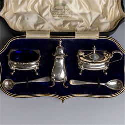 1920s silver three piece cruet set, comprising mustard pot and cover, pepper shaker and open salt, together with two matched silver cruet spoons, all hallmarked, contained within fitted tooled leather case