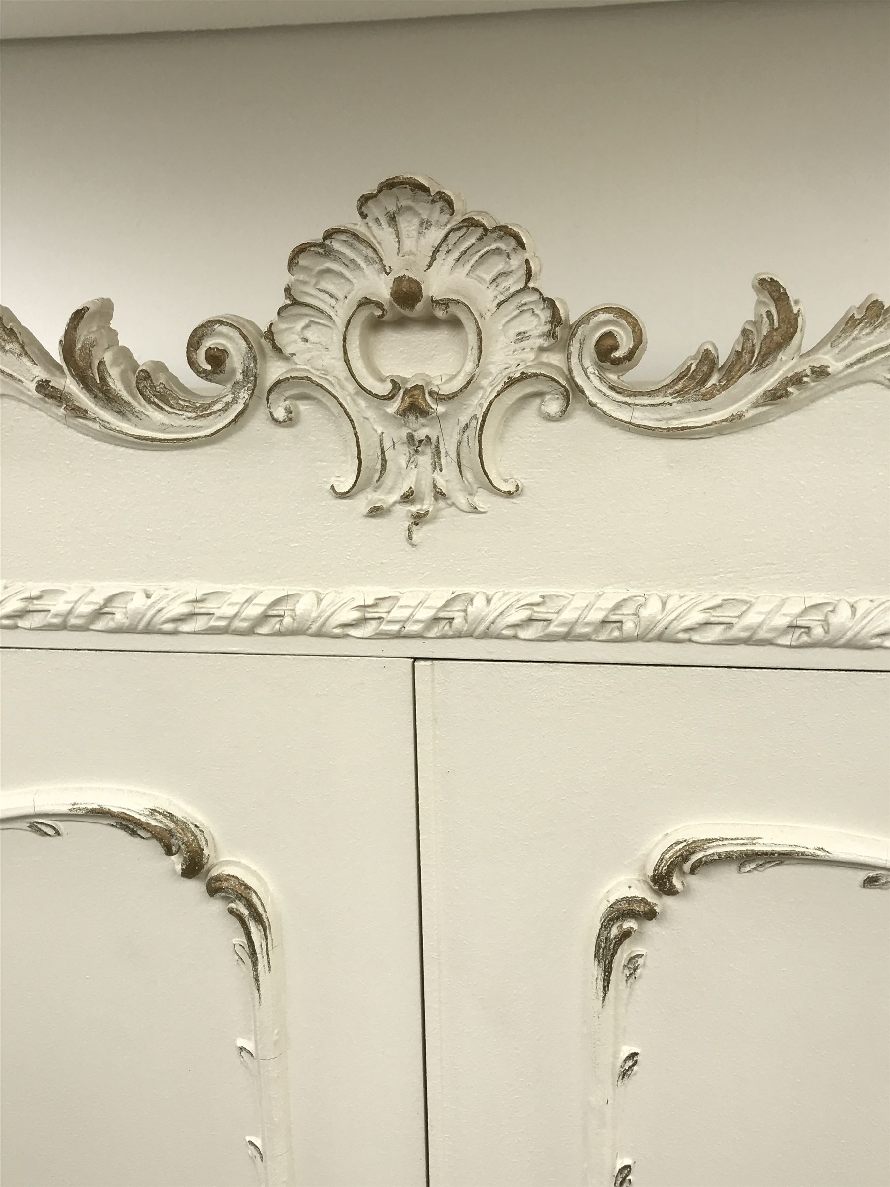 Late 20th century French style white and gilt double wardrobe,  shell carved cresting rail, two doors enclosing fitted interior, shaped bracket supports